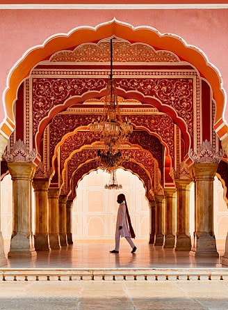 Guard walking under arches at the City Palace, Jaipur, Rajasthan