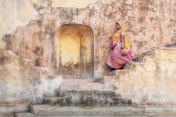 Woman climbing down the stairs at Chand Baori Stepwell, Abhaneri, Rajasthan