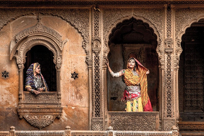 Donna del Rajasthan in abito tradizionale a una finestra del Patwon ki Haveli, Jaisalmer, Rajasthan