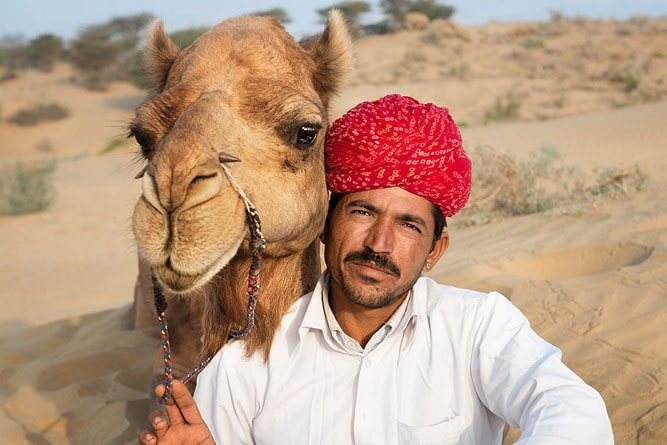 Ritratto di un uomo con turbante e cammello, deserto del Thar (Sam Sand Dunes), Jaisalmer, Rajasthan